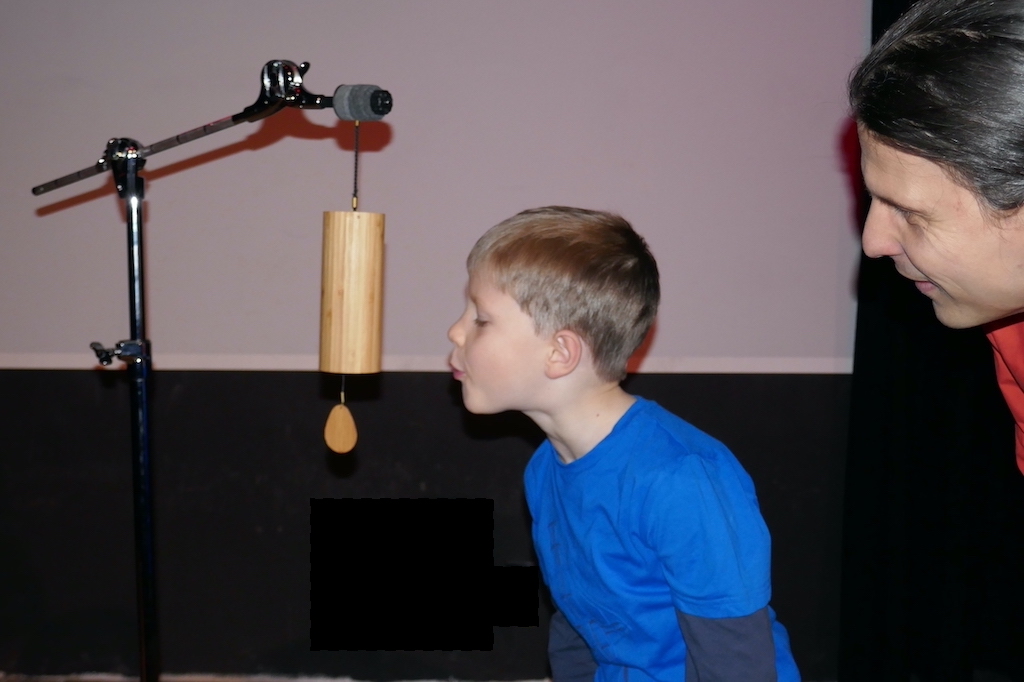 Junge pustet an das Klangspiel